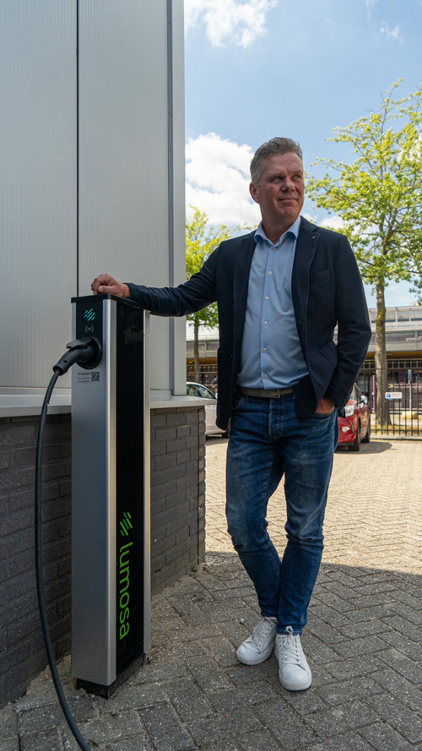 Jos de Greef van Ricoh Document Center Brabant staat bij een Lumosa TRACK laadpaal op de kantoorlocatie in Eindhoven.