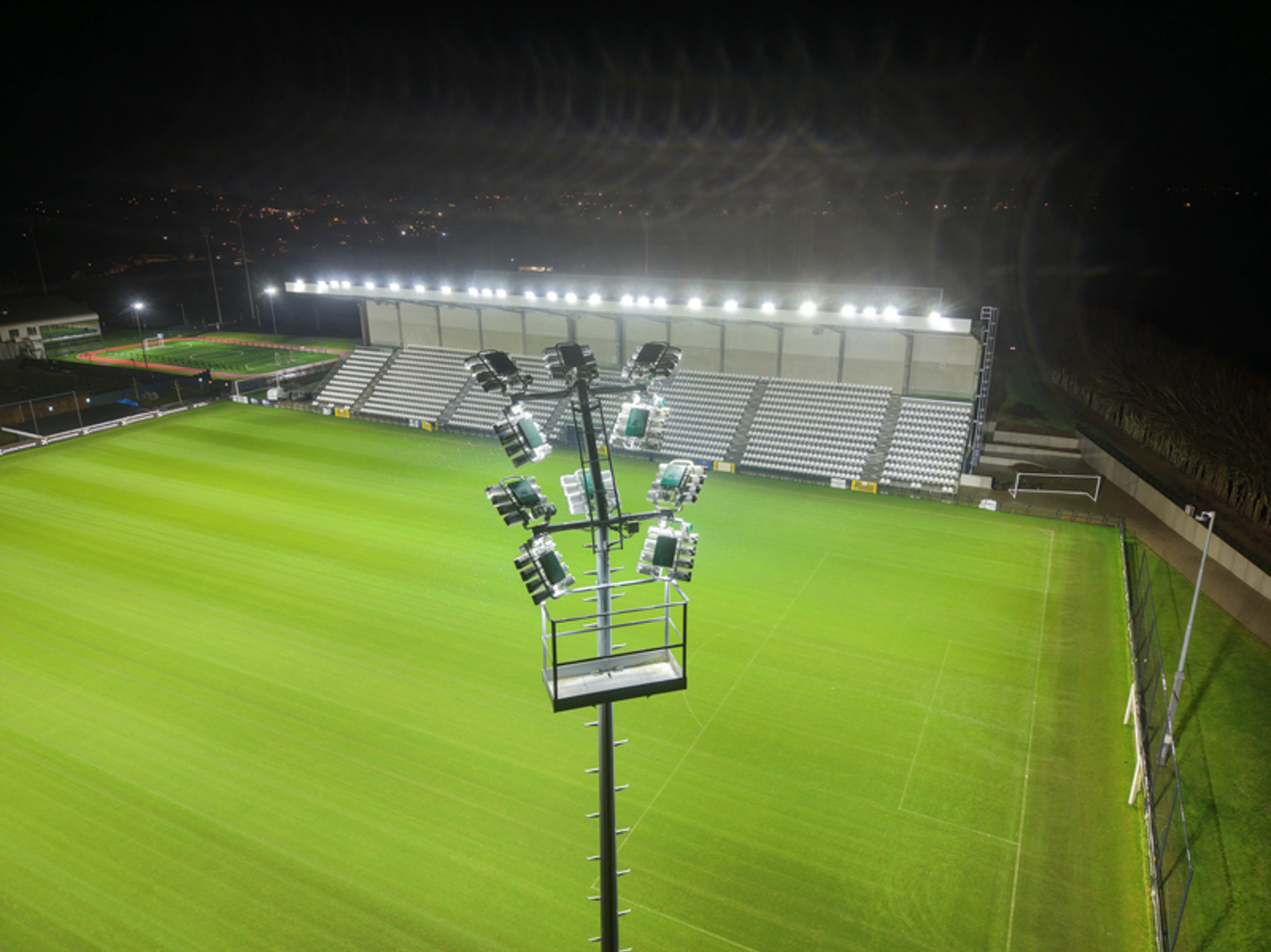 Lichtmast met Lumosa LED sportveldverlichting op Proximus Basecamp voor gelijkmatige verlichting van de trainingsvelden van de Rode Duivels.