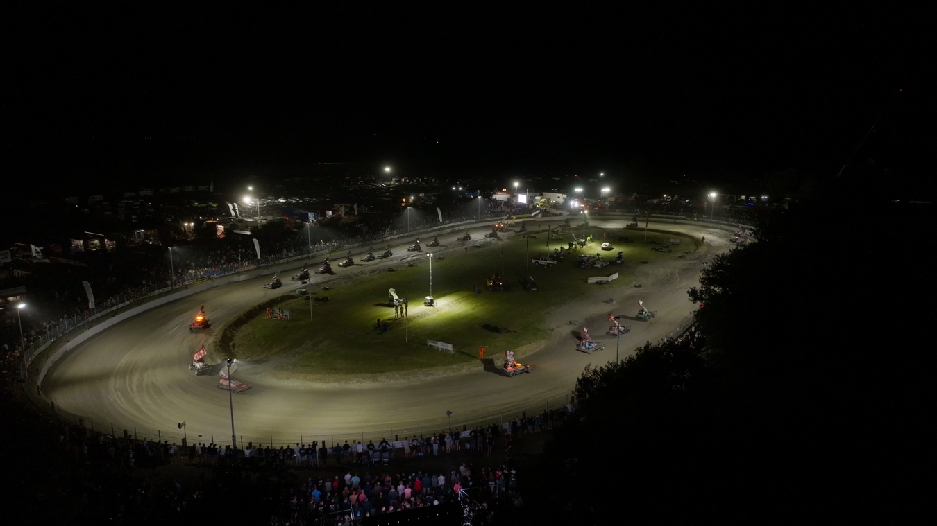Luchtbeeld van de ACON autocrossbaan tijdens een avondrace, waarbij Lumosa LED verlichting het volledige racecircuit verlicht.